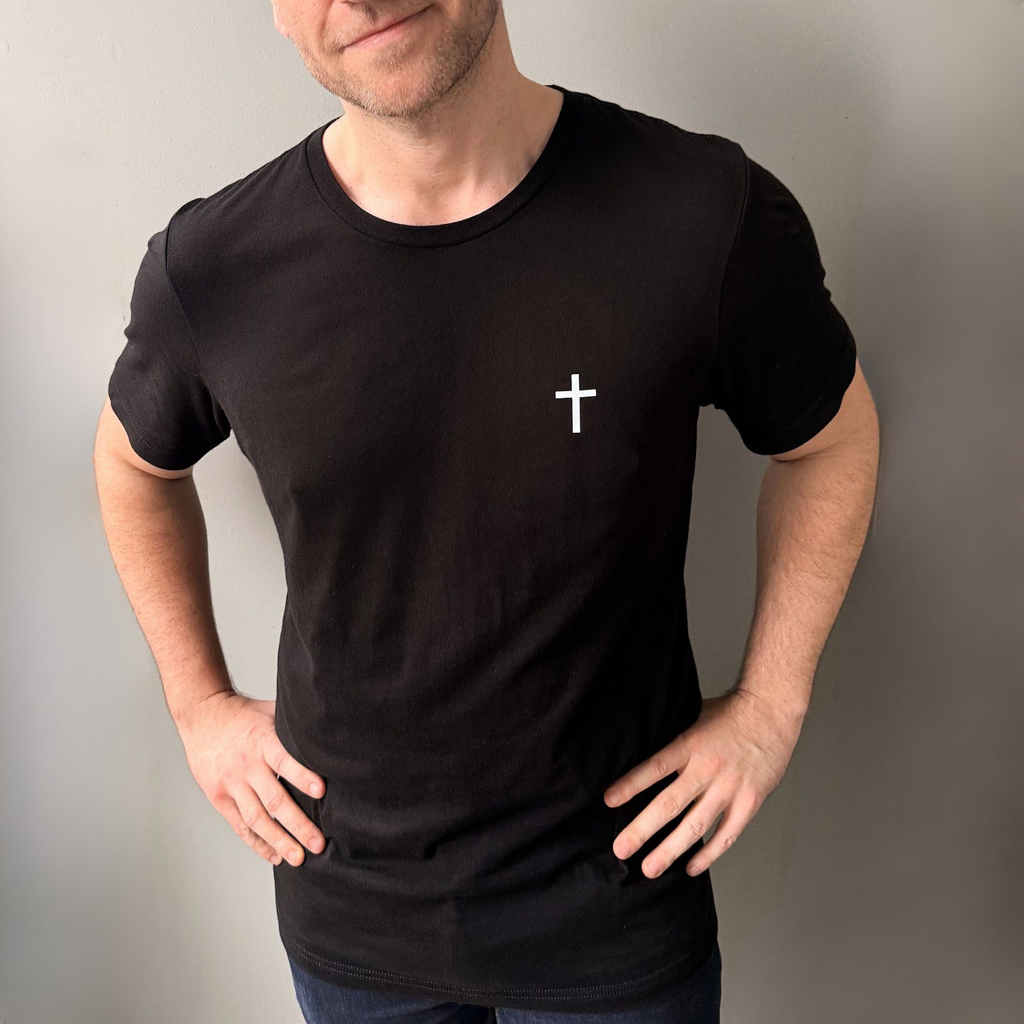 Chris wears a black christian t shirt with white cross