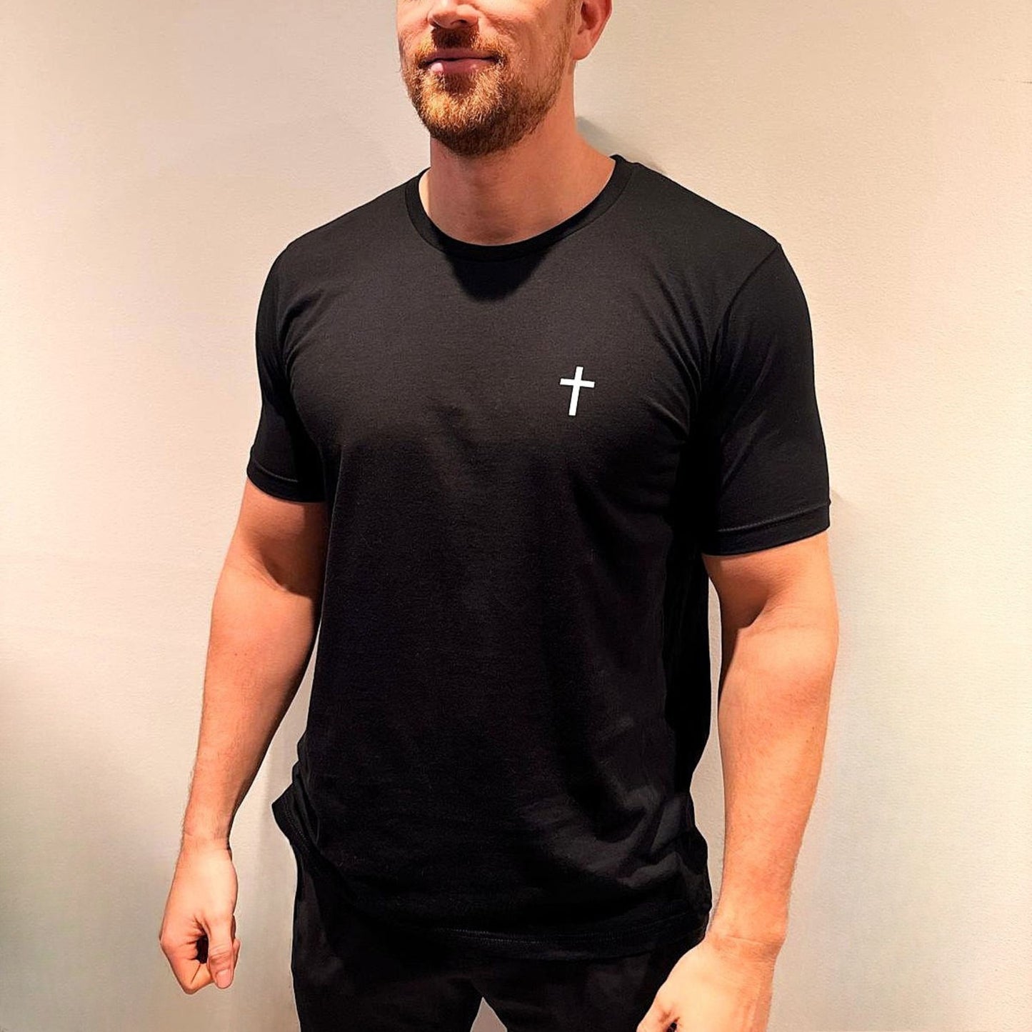 Mark wears black christian t shirt with white cross